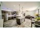 Modern kitchen with stainless steel appliances, gray cabinets, oversized island, and stylish pendant lighting fixtures at 4706 Cayo Costa Pl, Bradenton, FL 34203