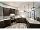 Open kitchen featuring a large quartz countertop island, stainless steel appliances, and modern light fixtures at 4706 Cayo Costa Pl, Bradenton, FL 34203