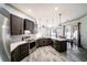 Open concept kitchen featuring granite countertops, dark wood cabinets, stainless steel appliances, and wood-look floors at 4706 Cayo Costa Pl, Bradenton, FL 34203