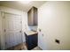 Bright laundry area with wood-look tile floors, gray cabinets, and granite countertop at 4706 Cayo Costa Pl, Bradenton, FL 34203
