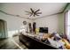 Open-concept living room featuring a decorative ceiling fan, wood-look floors, and a comfortable couch at 4706 Cayo Costa Pl, Bradenton, FL 34203