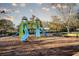 Community playground with slides, climbing structures and benches surrounded by mature trees at 4706 Cayo Costa Pl, Bradenton, FL 34203