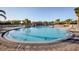 Outdoor community pool with a large deck area and views of the surrounding greenery and clear blue sky at 4706 Cayo Costa Pl, Bradenton, FL 34203