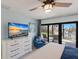 Main bedroom with ceiling fan, television, dresser, and waterfront views from private patio at 500 Halyard Ln, Longboat Key, FL 34228