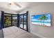 Bright bedroom with large windows showing a view of the channel and a mounted television at 500 Halyard Ln, Longboat Key, FL 34228