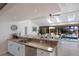 Kitchen overlooking the pool area with white cabinetry, granite countertops, stainless steel appliances and sink at 500 Halyard Ln, Longboat Key, FL 34228