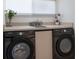 Laundry room area featuring side-by-side washer and dryer, a sink and granite countertops at 500 Halyard Ln, Longboat Key, FL 34228