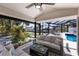 Comfortable covered patio with ceiling fan, and waterfront views of the pool and dock at 500 Halyard Ln, Longboat Key, FL 34228
