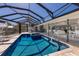 Enclosed pool area with lounge chairs, a covered seating area and access to the home at 500 Halyard Ln, Longboat Key, FL 34228