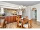 Cozy dining area featuring wood floors and a round wood table with seating under a chandelier at 5223 Chase Oaks Dr, Sarasota, FL 34241