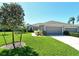Attractive gray home with a well-manicured lawn, mature landscaping, and a two-car garage at 5223 Chase Oaks Dr, Sarasota, FL 34241