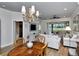 Elegant living room with wood floors, a chandelier, and a serene view of the lush backyard at 5223 Chase Oaks Dr, Sarasota, FL 34241