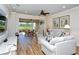 Bright living room featuring wood floors, modern furniture, and a view of the screened-in patio at 5223 Chase Oaks Dr, Sarasota, FL 34241