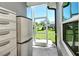 Covered porch with screen door overlooking beautifully landscaped yard with palm trees at 5223 Chase Oaks Dr, Sarasota, FL 34241
