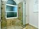 Glass shower enclosure with tiled walls, rain shower head and a window at 5223 Chase Oaks Dr, Sarasota, FL 34241