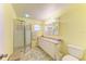 Bathroom with a tiled shower, vanity, and mirror, bathed in warm yellow tones for a cozy feel at 5311 San Jose Dr, Sarasota, FL 34235