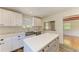 Open kitchen with stainless steel appliances, island, and white cabinets overlooks the connected living area at 5311 San Jose Dr, Sarasota, FL 34235