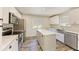 Kitchen with stainless steel appliances, center island and stylish wood-look flooring for a modern touch at 5311 San Jose Dr, Sarasota, FL 34235