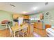 Cozy kitchen with light wood cabinetry, a small island cooktop, and an adjacent dining area with table and chairs at 5311 San Jose Dr, Sarasota, FL 34235
