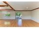 Spacious living room featuring wood floors, wooden beams, and sliding glass doors to a deck at 5311 San Jose Dr, Sarasota, FL 34235