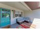 Inviting porch area with a comfy couch, colorful rug, and a bright blue front door at 5311 San Jose Dr, Sarasota, FL 34235