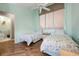 A well-lit bedroom with two beds, wood floors and a ceiling fan at 6263 Midnight Pass Rd # 301, Sarasota, FL 34242