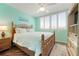 Cozy bedroom featuring a wicker bed frame, a large window, and beach-themed decor at 6263 Midnight Pass Rd # 301, Sarasota, FL 34242
