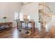 Bright dining area with a high ceiling, featuring modern bar stools, wood floors, and a spiral staircase at 6263 Midnight Pass Rd # 301, Sarasota, FL 34242