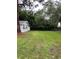 View of the large private backyard featuring lush greenery, grass, and mature trees at 6434 5Th W St, Bradenton, FL 34207