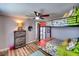 Bright bedroom features a twin bunk bed, ceiling fan, wood floors, and a gray dresser with lamp at 6434 5Th W St, Bradenton, FL 34207