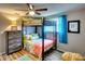 Cozy bedroom features a twin bunk bed, wood floors, and a gray dresser at 6434 5Th W St, Bradenton, FL 34207