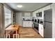 Modern kitchen featuring stainless steel appliances, white cabinets, and a dining area with natural light at 6434 5Th W St, Bradenton, FL 34207