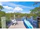 A private dock boasts serene water views, complete with a chair, side table, and paddleboard at 700 Tropical Cir, Sarasota, FL 34242