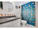 Charming bathroom featuring a vanity, toilet, and a tub with a whimsical fish-themed shower curtain at 709 Riverview Cir, North Port, FL 34287