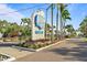 Harbor Cove waterfront community entrance with lush landscaping and palm tree lined streets at 709 Riverview Cir, North Port, FL 34287