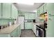 Charming kitchen with mint-green cabinetry and modern appliances at 709 Riverview Cir, North Port, FL 34287