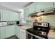 Charming kitchen featuring mint green cabinets, updated appliances, and ample counter space at 709 Riverview Cir, North Port, FL 34287