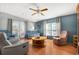 Comfortable living room featuring cozy armchairs, wood floors, and a ceiling fan at 709 Riverview Cir, North Port, FL 34287