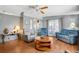 Open-concept living room with wood floors, comfortable seating, and access to the dining area at 709 Riverview Cir, North Port, FL 34287