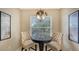 Cozy breakfast nook with tufted chairs, stylish chandelier, and a view to the outdoors at 7609 Sweetbay Cir # 7609, Bradenton, FL 34203