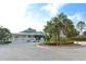 Beautiful view of the clubhouse exterior with lush landscaping and a convenient golf cart at 7609 Sweetbay Cir # 7609, Bradenton, FL 34203