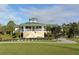 Exterior view of golf course clubhouse featuring lush landscaping, manicured lawns, and a sprawling green roof at 7609 Sweetbay Cir # 7609, Bradenton, FL 34203