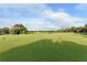 Scenic golf course putting green with neatly trimmed grass and black and yellow pin flags under a bright sky at 7609 Sweetbay Cir # 7609, Bradenton, FL 34203