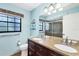 Bathroom featuring dual sinks, granite countertop, window, and glass-enclosed shower at 8036 Conservatory Cir, Sarasota, FL 34243
