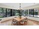 Bright dining room with large windows, wood floors, and a modern chandelier at 8036 Conservatory Cir, Sarasota, FL 34243