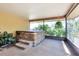 Relaxing screened-in hot tub room with tile steps and a serene view of the greenery outside at 8036 Conservatory Cir, Sarasota, FL 34243