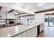Open kitchen with granite countertops, a bar, and a view of the stone fireplace in the living room at 8036 Conservatory Cir, Sarasota, FL 34243