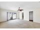 Spacious carpeted living room with ceiling fan and sliding glass doors leading to the outdoors at 8036 Conservatory Cir, Sarasota, FL 34243