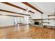 Spacious living room featuring hardwood floors, wood beams, and a stone fireplace at 8036 Conservatory Cir, Sarasota, FL 34243