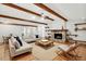 Inviting living room featuring a stone fireplace, wood beams, and hardwood floors at 8036 Conservatory Cir, Sarasota, FL 34243